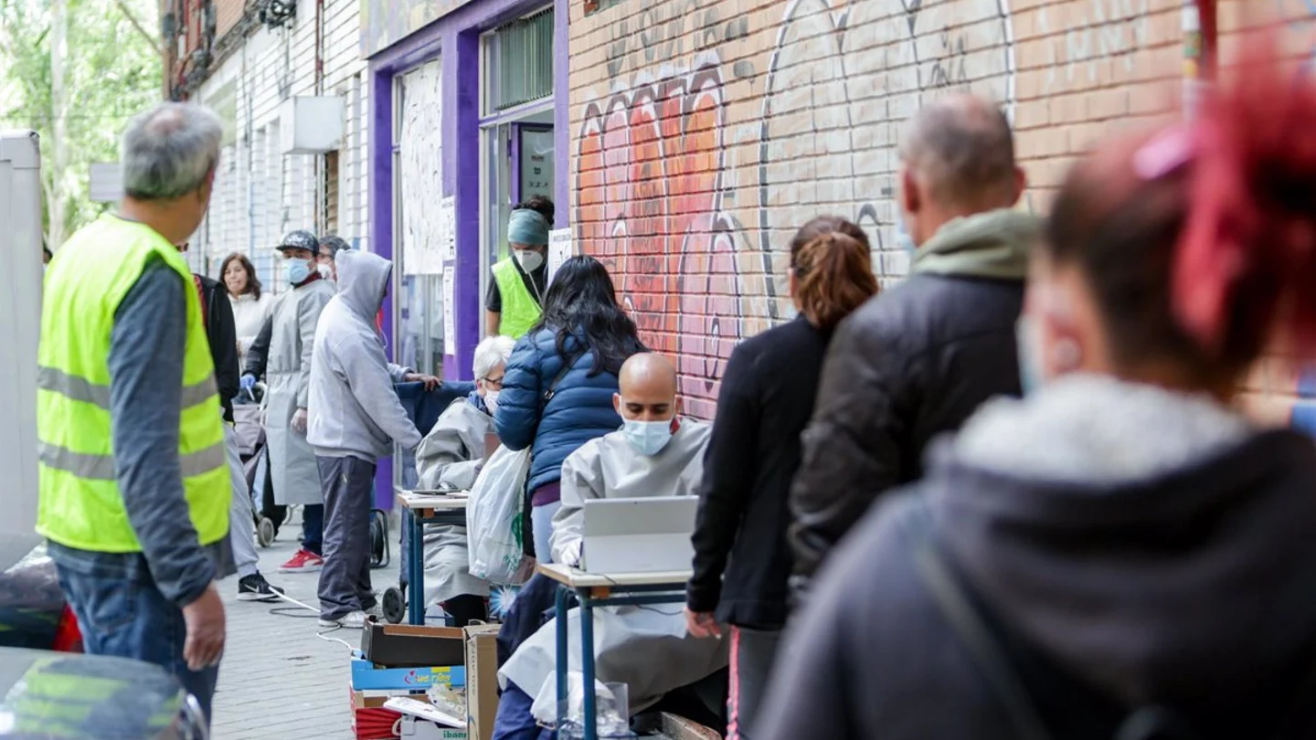 Vecinos realizan una cola para recoger bolsas de la Asociación de Vecinos Parque Aluche Vecinos realizan una cola para recoger bolsas de la Asociación de Vecinos Parque Aluche