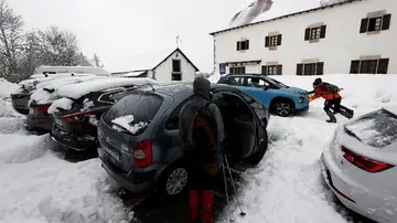  Dos personas empujan un vehículo que ha quedado atrapado en la nieve en el parking de Roncesvalles 