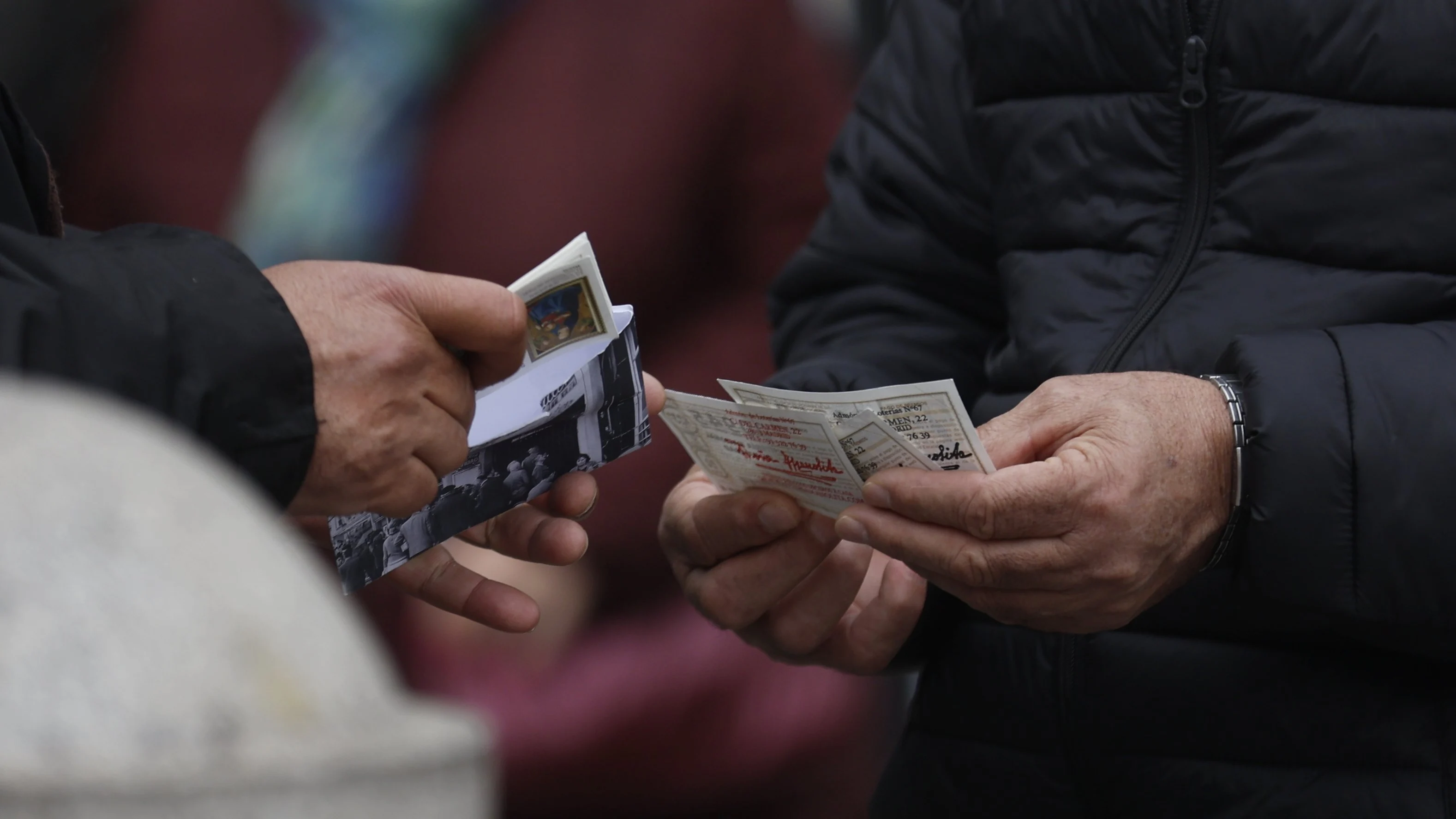 Varias personas mirando sus décimos a pocos días de que se celebre el Sorteo