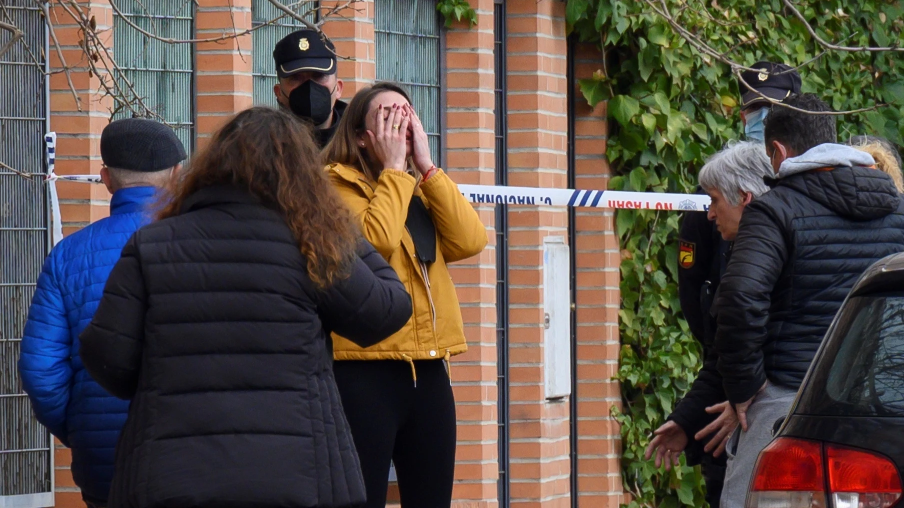 Agentes del Cuerpo Nacional de Policía y efectivos de Emergencias Sanitarias atienden a los familiares de la mujer asesinada