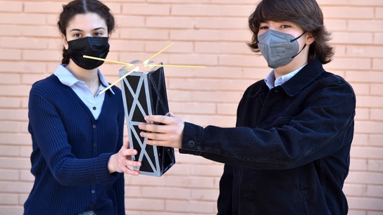 Dos alumnos sostienen una maqueta del satélite. Dos alumnos sostienen una maqueta del satélite.