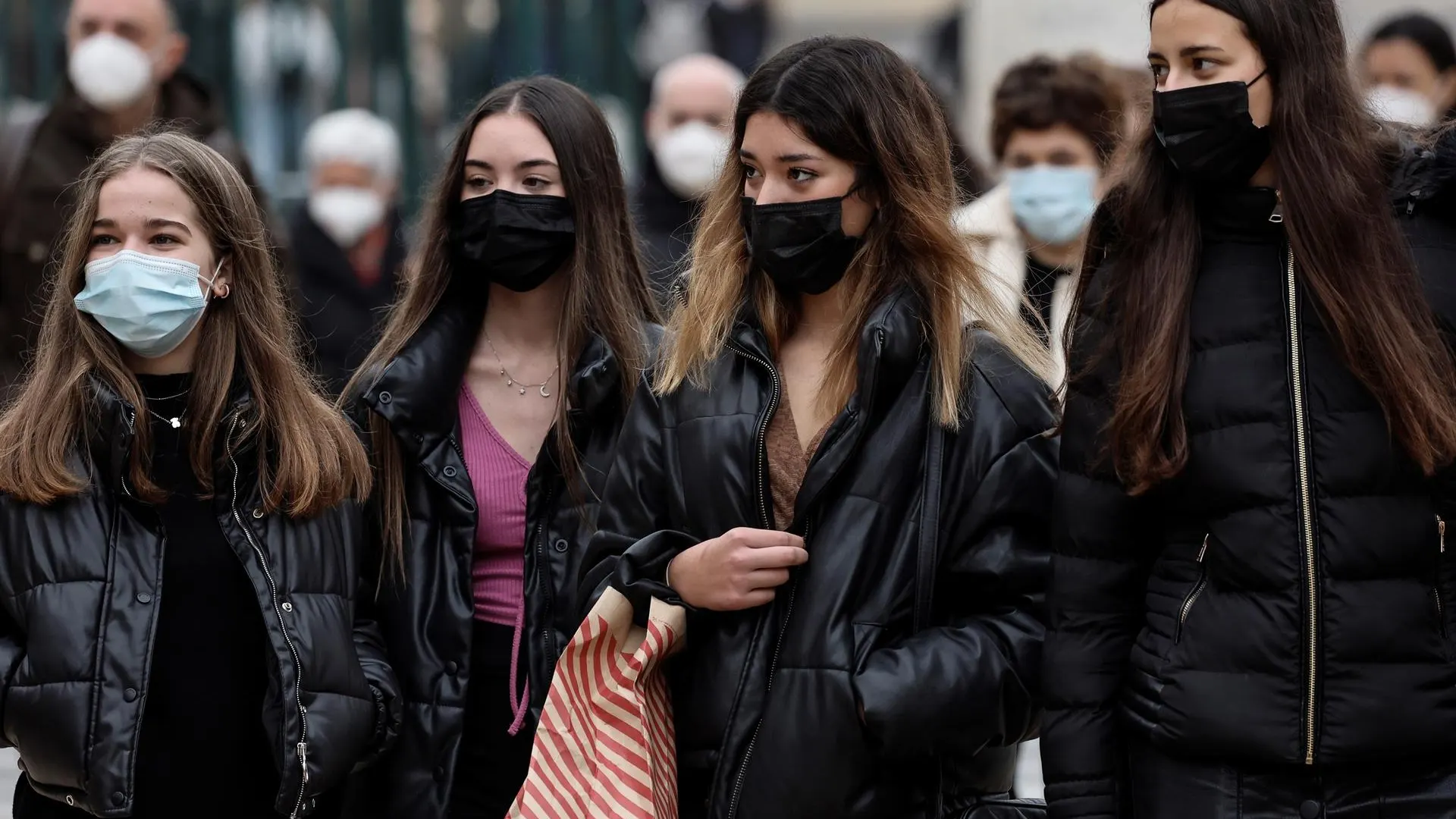 Personas caminando por la calle con mascarillas