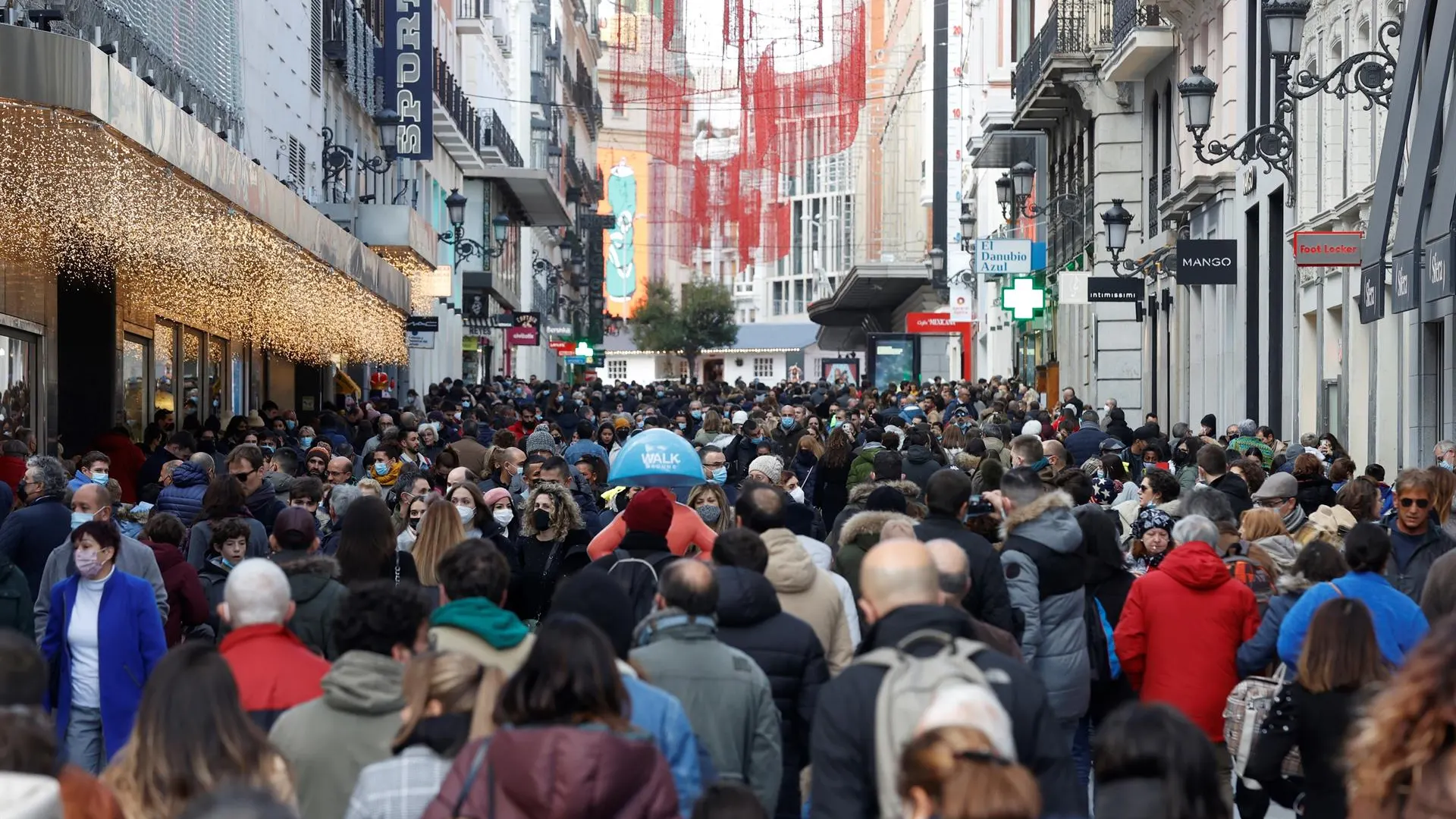 Ciudadanos caminando por la calle con mascarillas