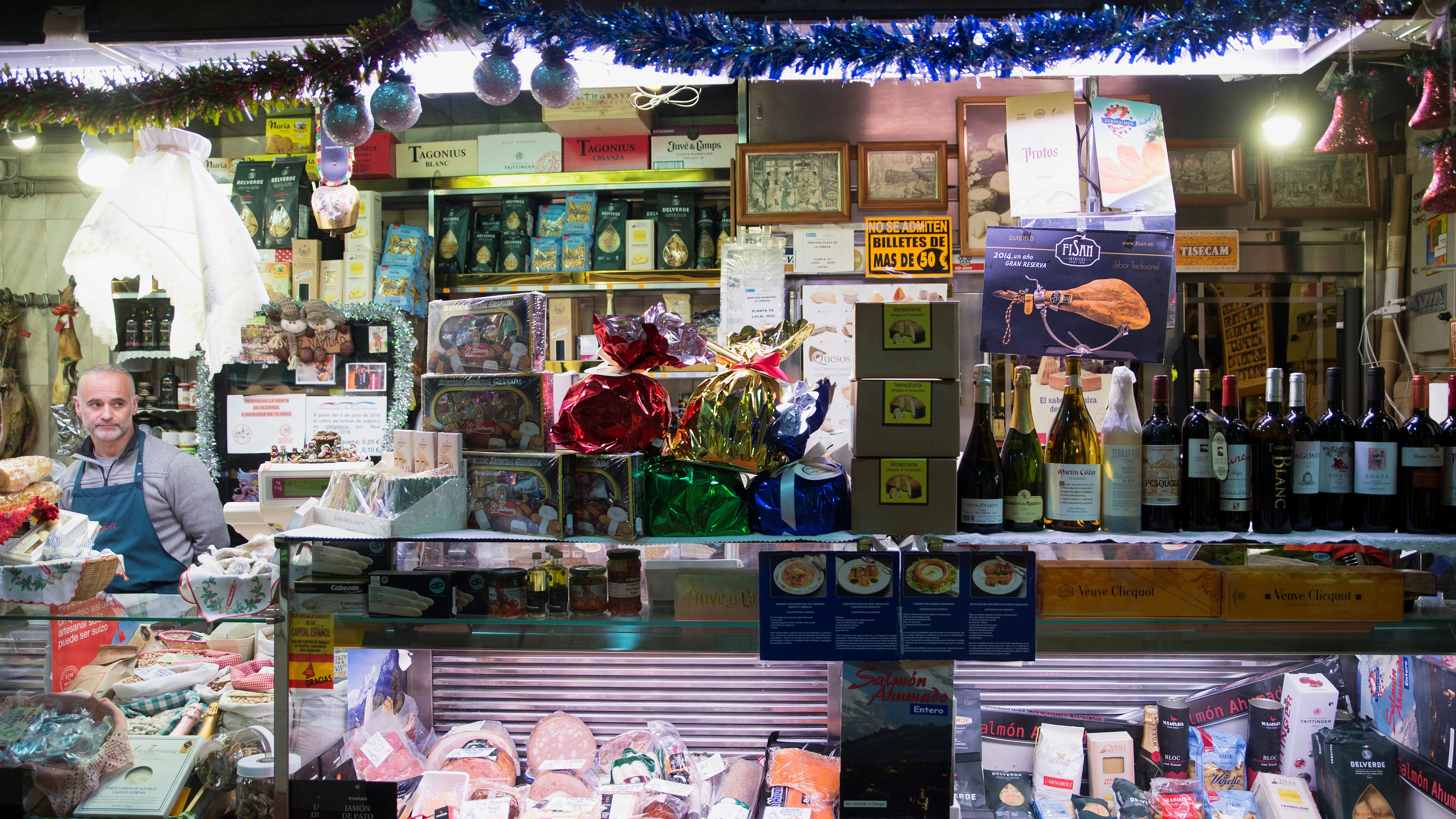 Varios productos son expuestos en una tienda del mercado de la Cebada en Madrid, durante las compras de los productos más típicos para las comidas navideñas.