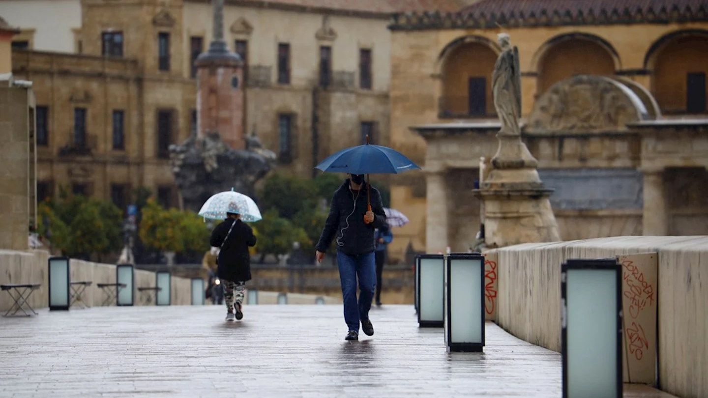 Imagen de archivo de dos personas paseando bajo la lluvia en Córdoba Imagen de archivo de dos personas paseando bajo la lluvia en Córdoba