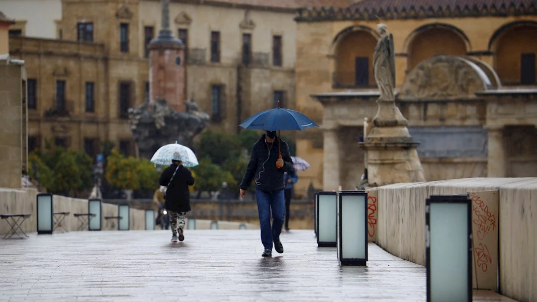 Imagen de archivo de dos personas paseando bajo la lluvia en Córdoba