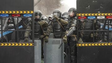 Policías antidisturbios vigilan una calle durante las manifestaciones