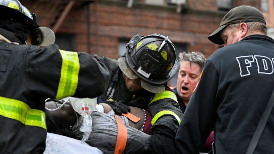 Bomberos atienden a una de las personas afectadas en el incendio del Bronx (Nueva York, EEUU)
