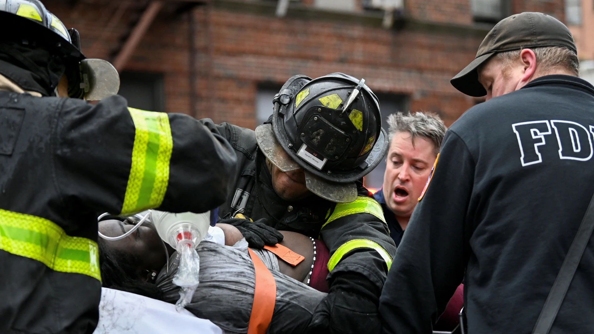 Bomberos atienden a una de las personas afectadas en el incendio del Bronx (Nueva York, EEUU)