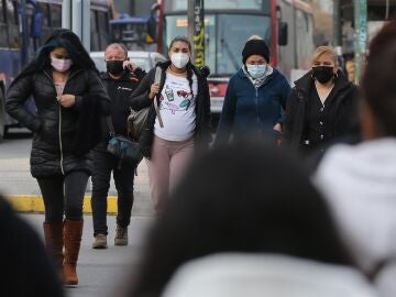 Personas andando por la calle con mascarillas