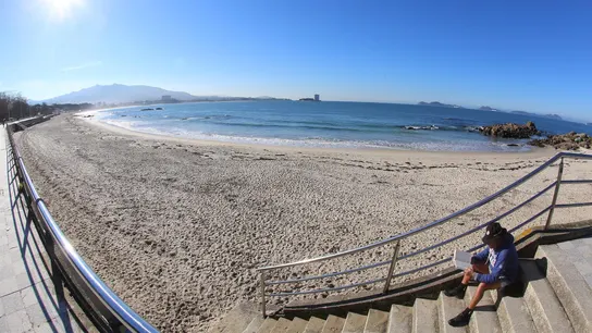 Un hombre lee en la playa de Samil de Vigo Un hombre lee en la playa de Samil de Vigo