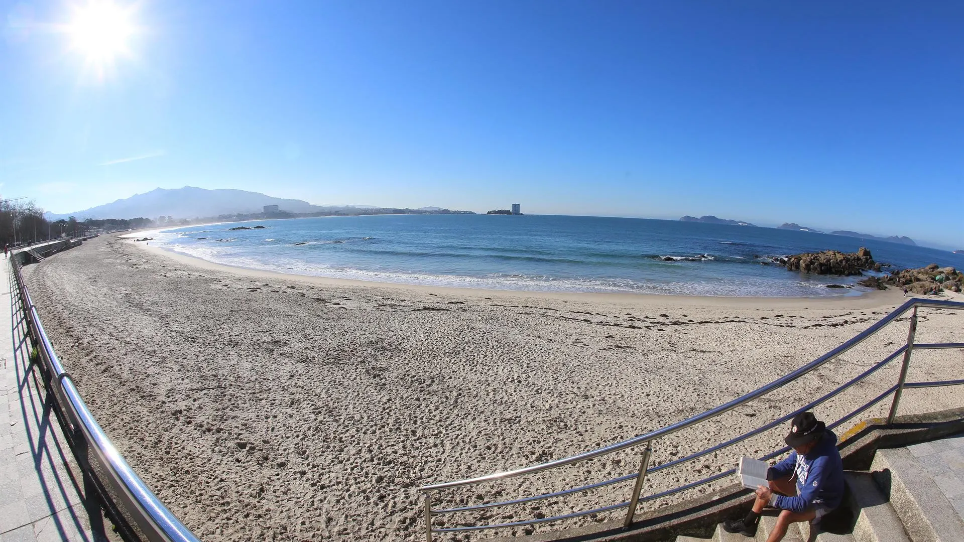 Un hombre lee en la playa de Samil de Vigo