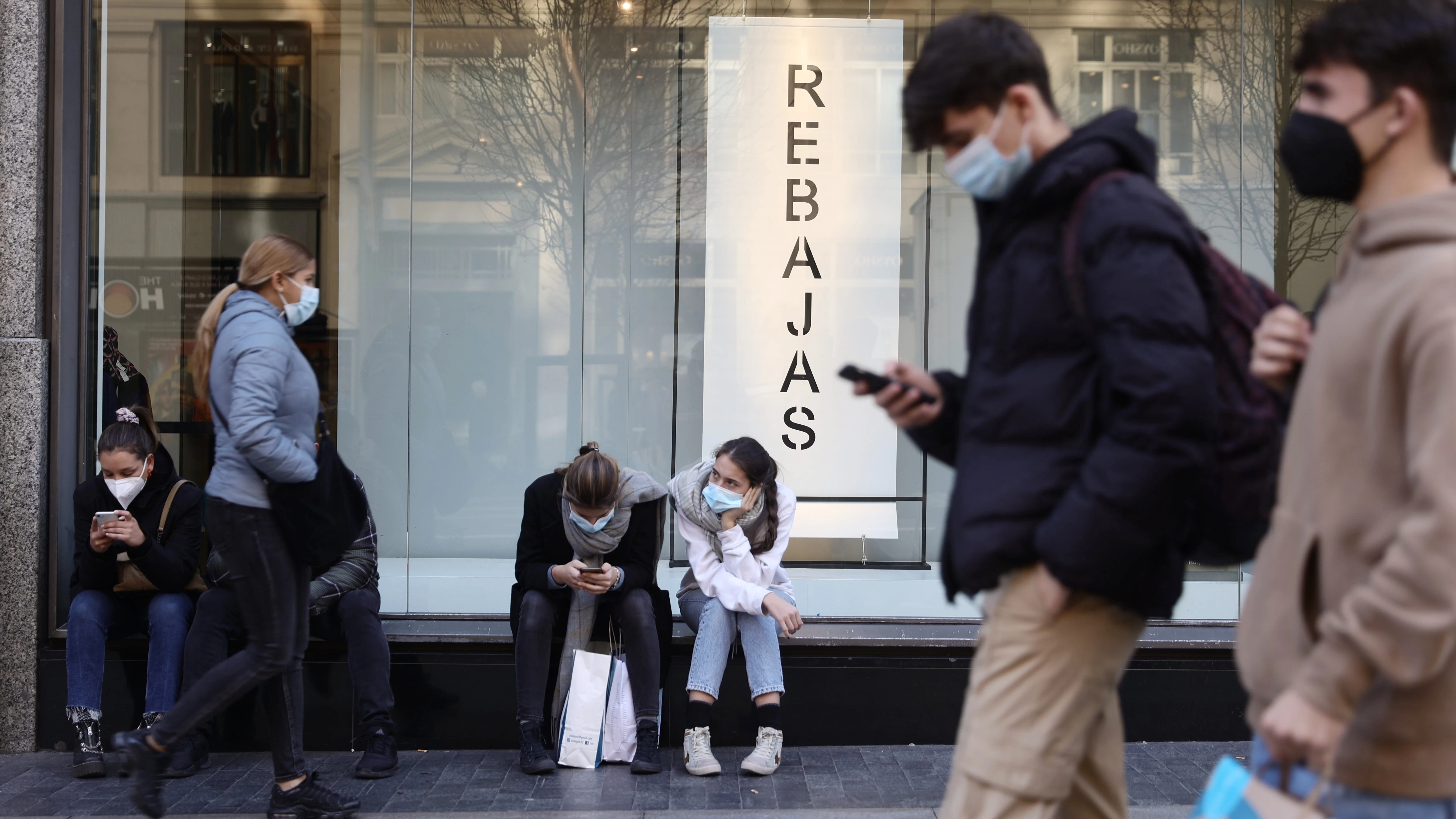 Personas con mascarilla en una calle comercial de Madrid