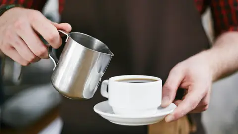 Camarero ofreciendo café en una cafetería Camarero ofreciendo café en una cafetería