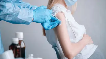 Mujer embarazada a la que le están administrando una vacuna