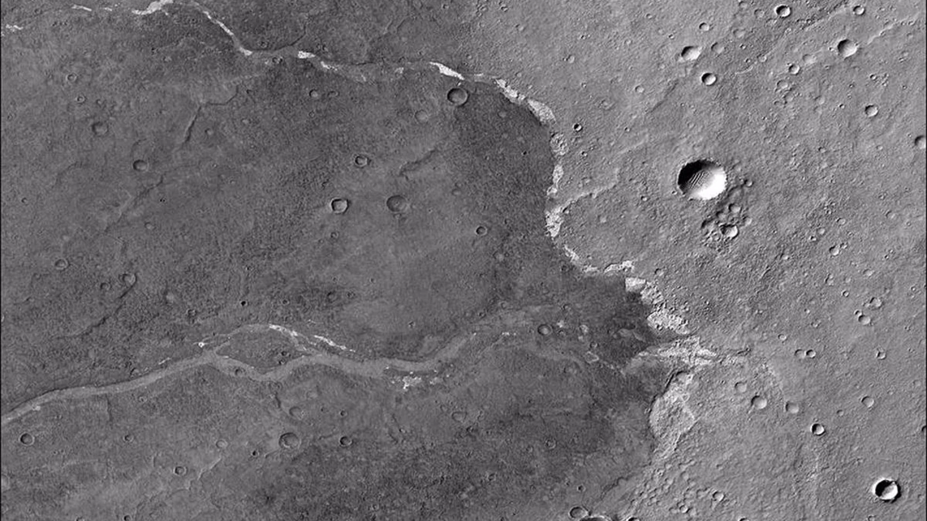 Las motas blancas son depósitos de sal que se encuentran dentro de un canal seco en Marte