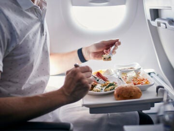 persona comiendo en un avión