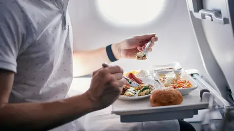 persona comiendo en un avión persona comiendo en un avión