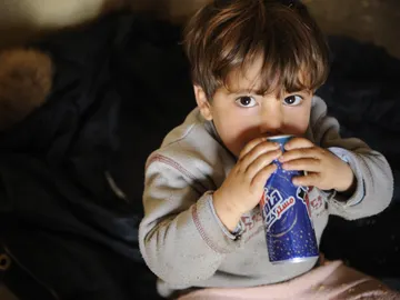 Niño consumiendo una bebida energética Niño consumiendo una bebida energética