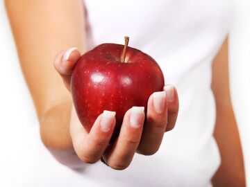mujer con una manzana en la mano