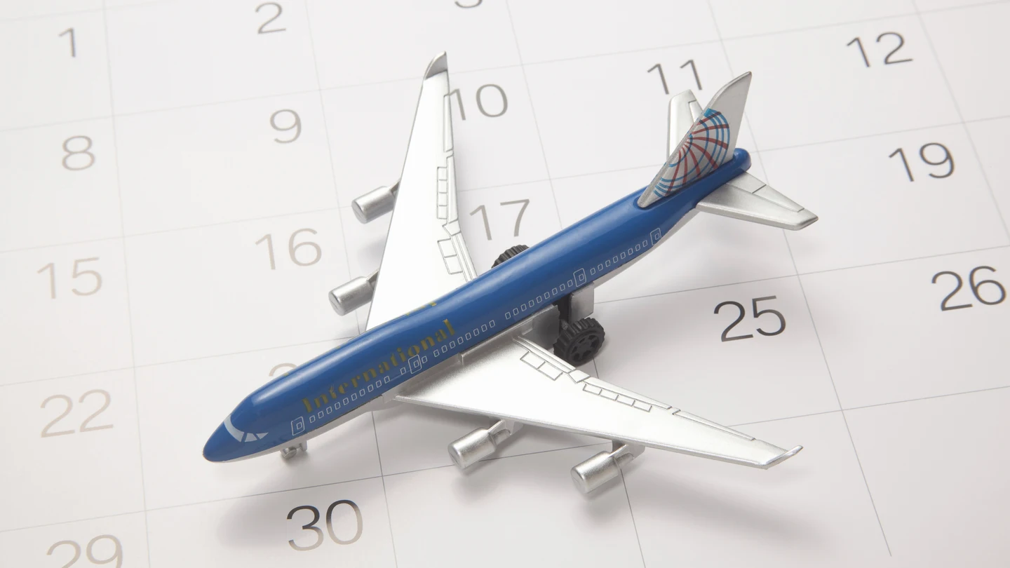 Imagen de archivo de un avión sobre un calendario Imagen de archivo de un avión sobre un calendario