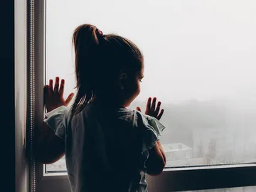 Niña asomada a la ventana Niña asomada a la ventana