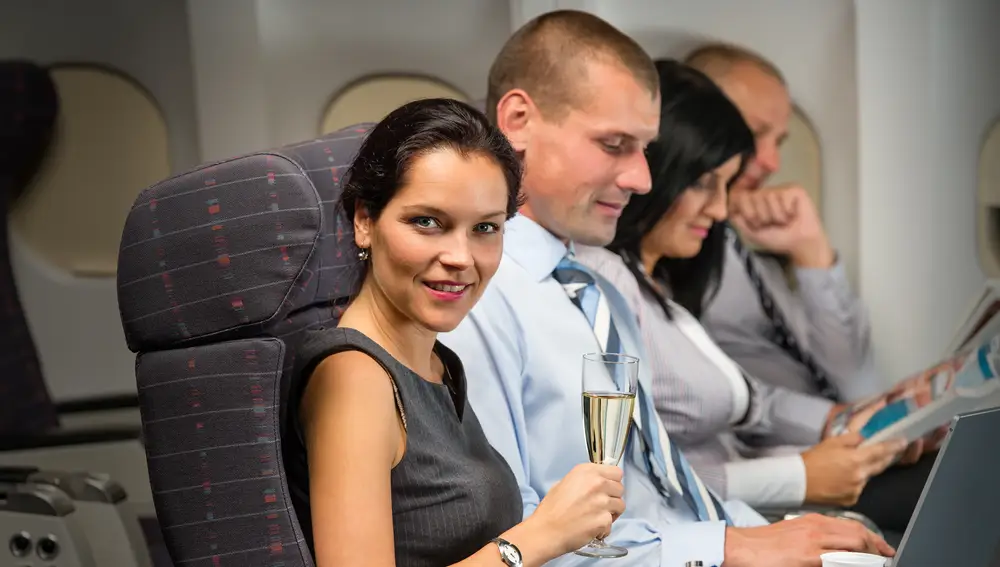 Personas viajando en business en avión