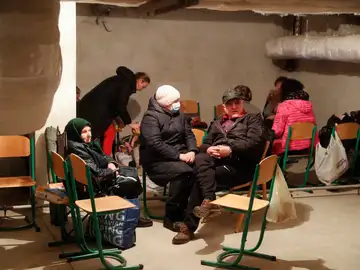 Varias personas usan el sótano de una escuela como refugio para pasar la noche en Kiev, Ucrania.
