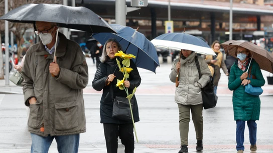 Un grupo de personas se protegen de la lluvia este viernes, 25 de febrero, en el centro de Madrid Un grupo de personas se protegen de la lluvia este viernes, 25 de febrero, en el centro de Madrid