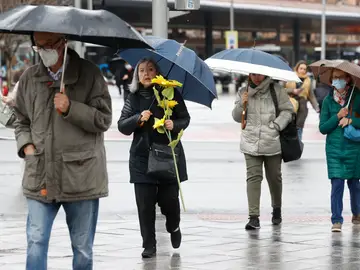 Un grupo de personas se protegen de la lluvia este viernes, 25 de febrero, en el centro de Madrid