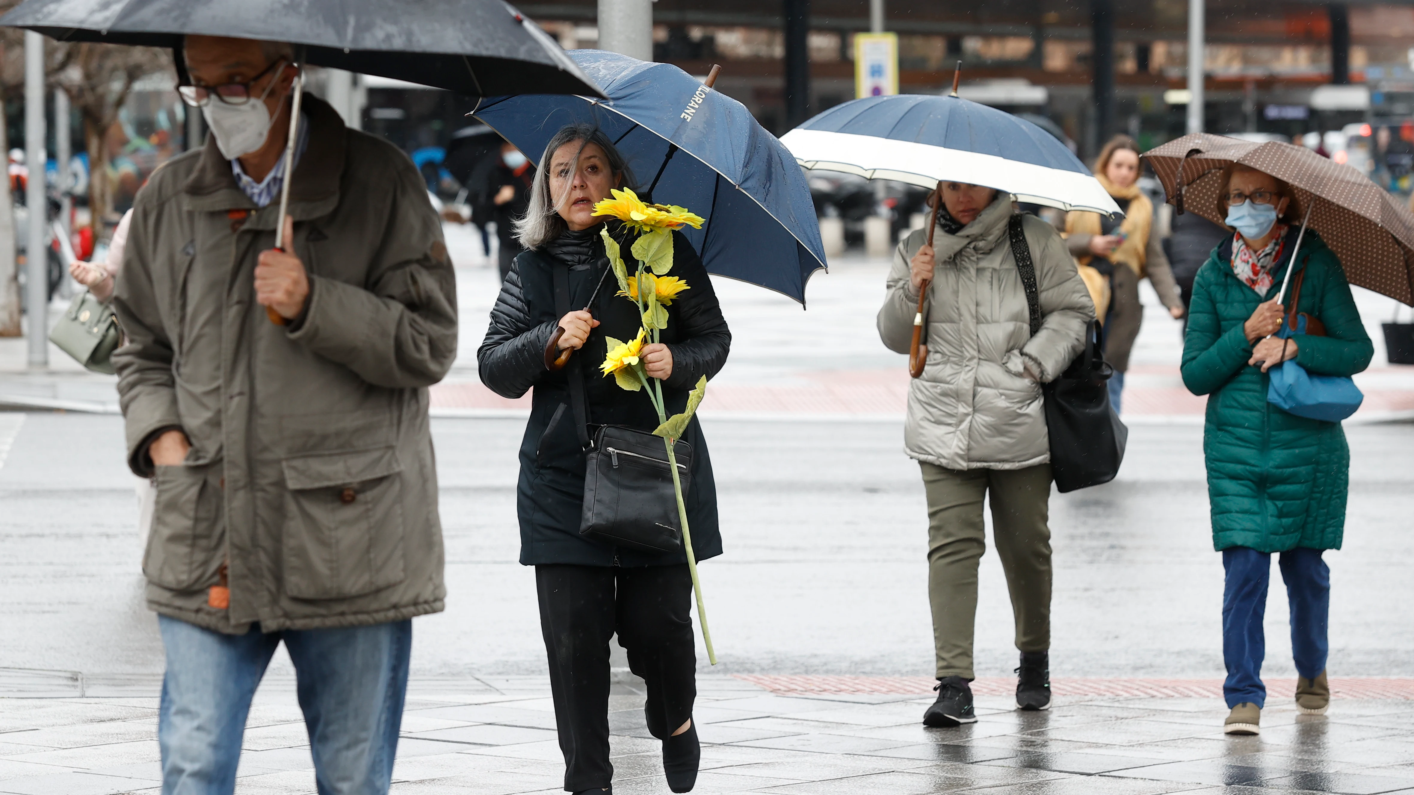 Un grupo de personas se protegen de la lluvia este viernes, 25 de febrero, en el centro de Madrid