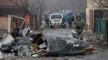 Un soldado pasa junto a los escombros de un avión militar que fue derribado en Kiev