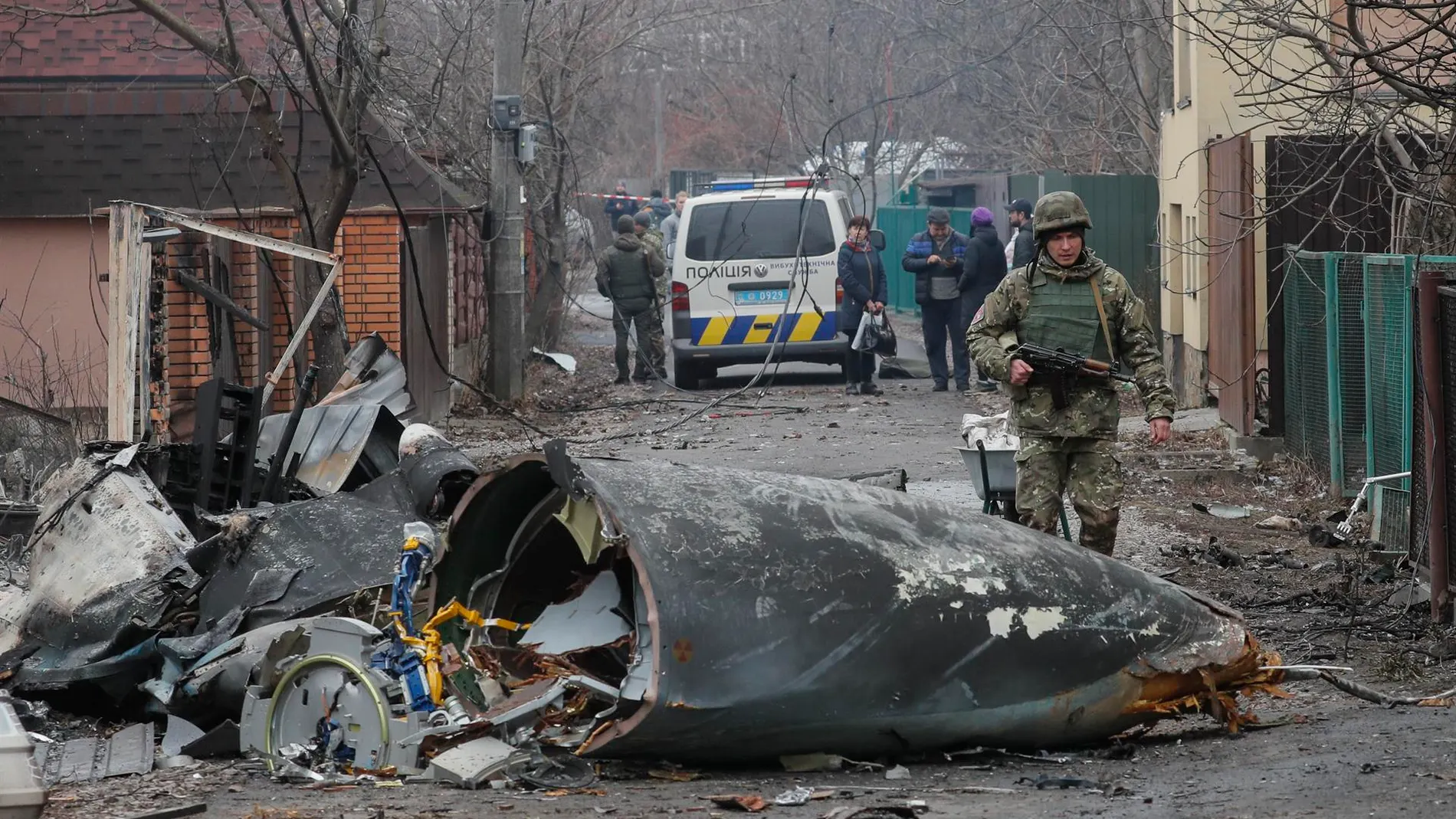 Un soldado pasa junto a los escombros de un avión militar que fue derribado en Kiev