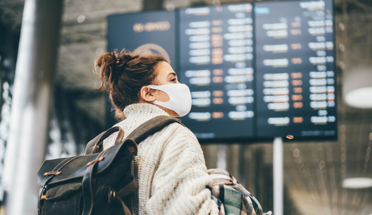 mujer con mascarilla en el aeropuerto