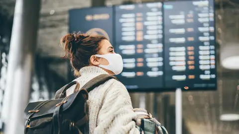 mujer con mascarilla en el aeropuerto mujer con mascarilla en el aeropuerto