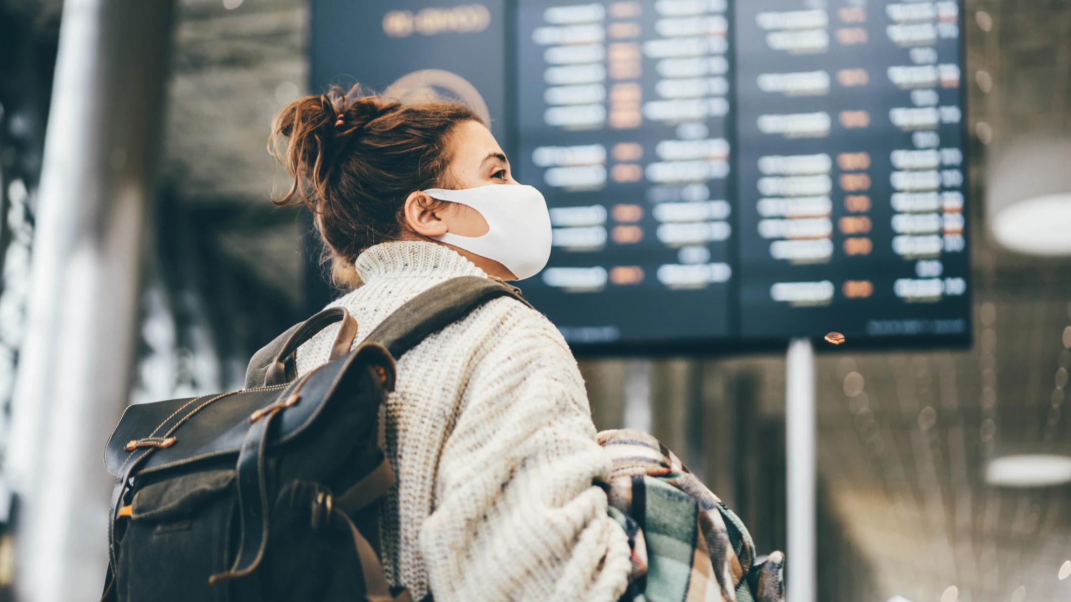 mujer con mascarilla en el aeropuerto