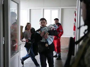 Un padre lleva a su hijo en brazos al hospital en Mariúpol