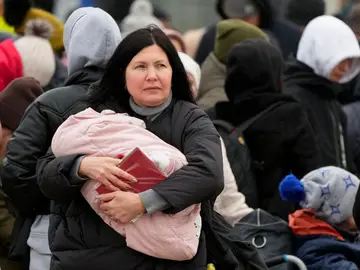 Una mujer lleva a su bebé que huye de la guerra desde la vecina Ucrania llega al cruce fronterizo en Palanca, Moldavia.