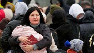 Una mujer lleva a su bebé que huye de la guerra desde la vecina Ucrania llega al cruce fronterizo en Palanca, Moldavia.