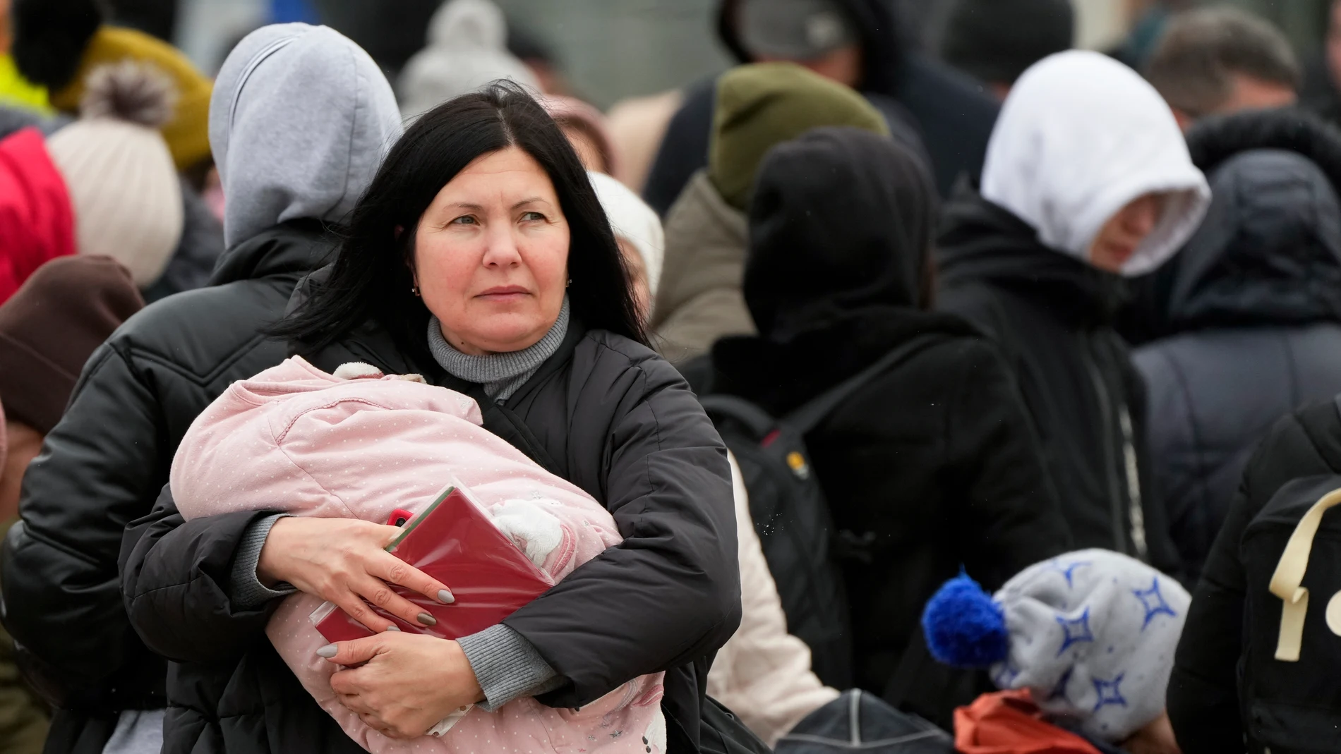 Una mujer lleva a su bebé que huye de la guerra desde la vecina Ucrania llega al cruce fronterizo en Palanca, Moldavia.