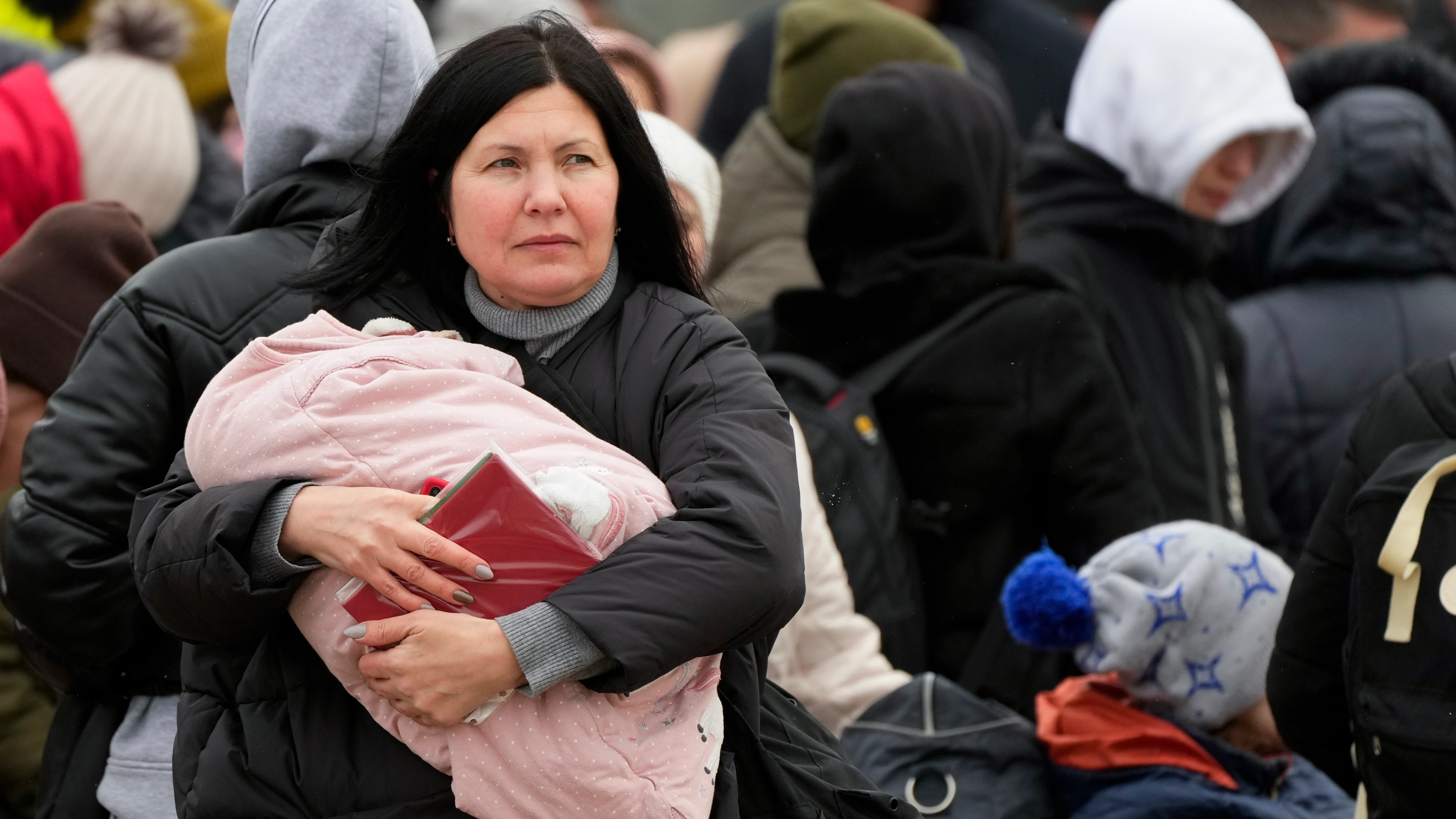 Una mujer lleva a su bebé que huye de la guerra desde la vecina Ucrania llega al cruce fronterizo en Palanca, Moldavia. 