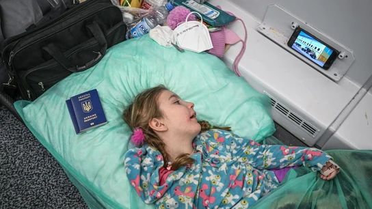 Un niña con una enfermedad crónica mira los dibujos animados en un teléfono móvil dentro de un vagón de tren transformado para el transporte médico Un 'tren hospital'