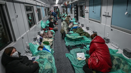 Madres sentadas junto a sus hijos en un vagón de tren transformado para el transporte médico Un 'tren hospital'