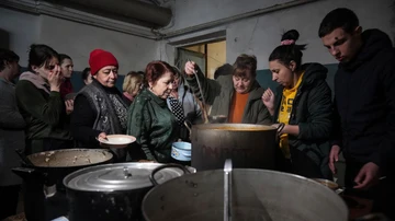 La gente hace cola para recibir comida caliente en un refugio antibombas improvisado en Mariupol