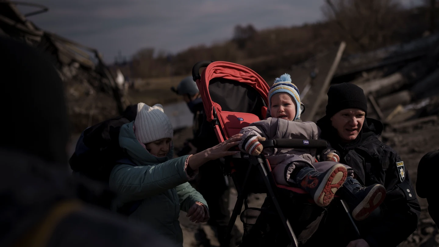 Un niño es llevado en un cochecito por un camino improvisado mientras huye de Irpin, en las afueras de Kiev Un niño es llevado en un cochecito por un camino improvisado mientras huye de Irpin, en las afueras de Kiev