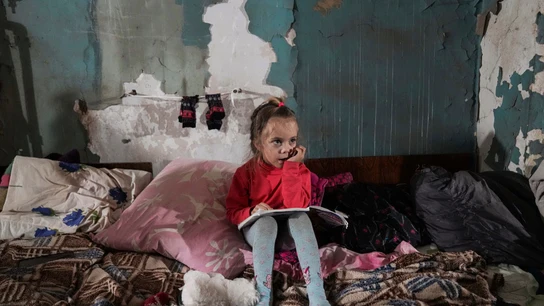 Una niña sentada en un refugio antibombas improvisado en Mariupol Una niña sentada en un refugio antibombas improvisado en Mariupol