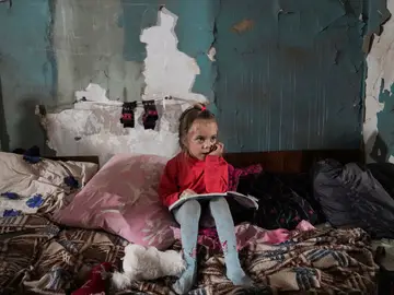 Una niña sentada en un refugio antibombas improvisado en Mariupol