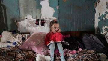 Una niña sentada en un refugio antibombas improvisado en Mariupol
