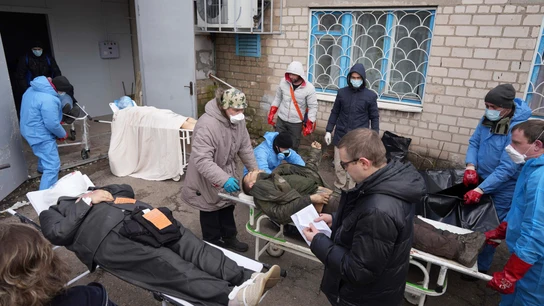 Los cadáveres se preparan antes de colocarlos en bolsas para cadáveres y enterrarlos en una fosa común en las afueras de Mariupol, Ucrania. Los cadáveres se preparan antes de colocarlos en bolsas para cadáveres y enterrarlos en una fosa común en las afueras de Mariupol, Ucrania.