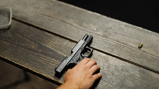 Imagen de archivo de una persona sujetando una pistola Imagen de archivo de una persona sujetando una pistola
